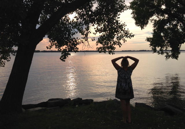 Julie silhouetted against lake sunset, Nebraska